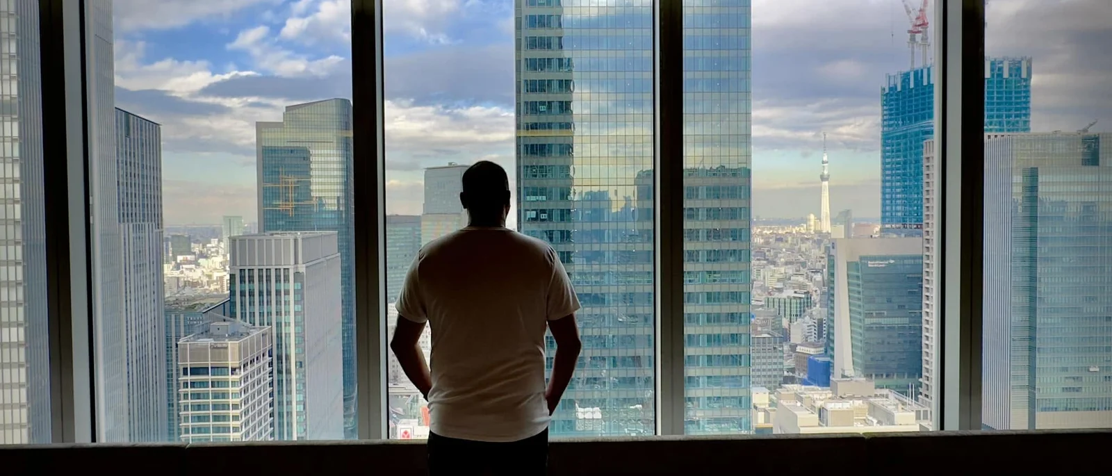 Elyes Baccar observing a city from a window